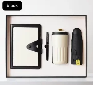 executive-black-cream-corporate-gift-set-notebook-tumbler.jpg Executive corporate gift box containing a black and cream snap-closure notebook, a sleek metal pen, a cream insulated tumbler, and a black compact umbrella.