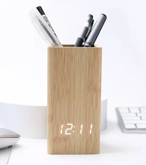 wooden-pen-holder-led-digital-desk-clock.jpg Natural wooden pen holder with integrated white digital LED clock holding pens on a clean white desk setup.