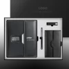 Black executive corporate gift set in an open presentation box, including a leather-bound notebook with an embedded digital clock display, a sleek ballpoint pen, a USB flash drive, and a small leather wallet or card holder.